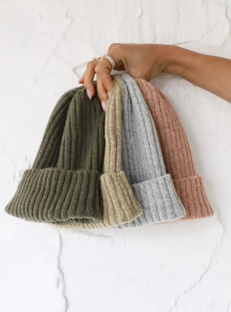 Collection of fuzzy cozy beanies in muted colors for your winter wardrobe.