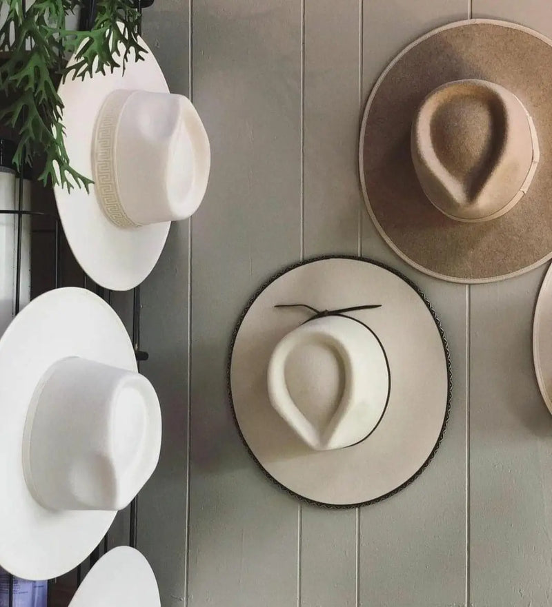 Collection of women’s hats featuring trendy bucket hats and neutral-toned straw hats.