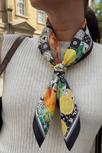 Person wearing a colorful scarf with lemon and orange patterns