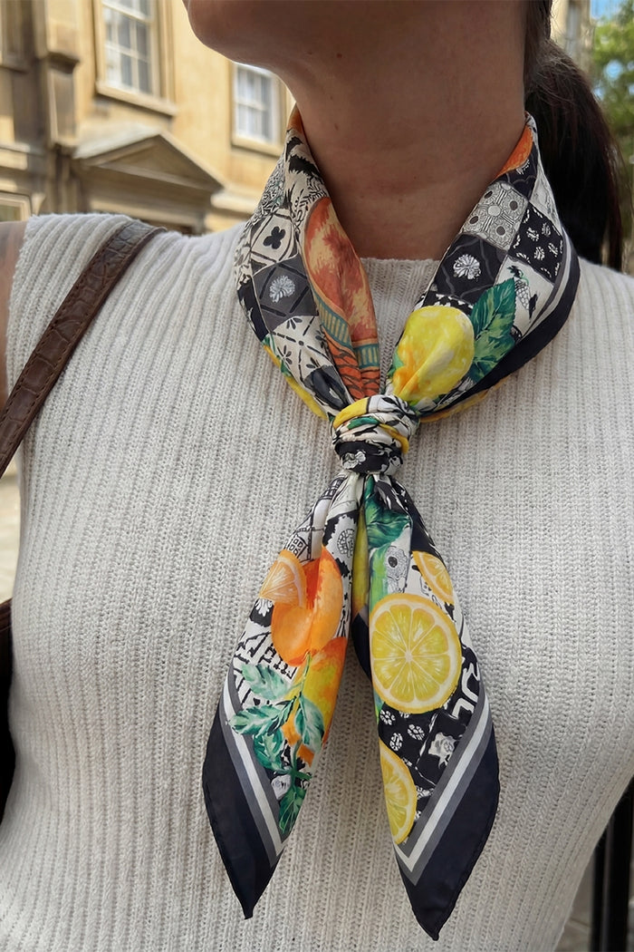 Person wearing a colorful scarf with lemon and orange patterns