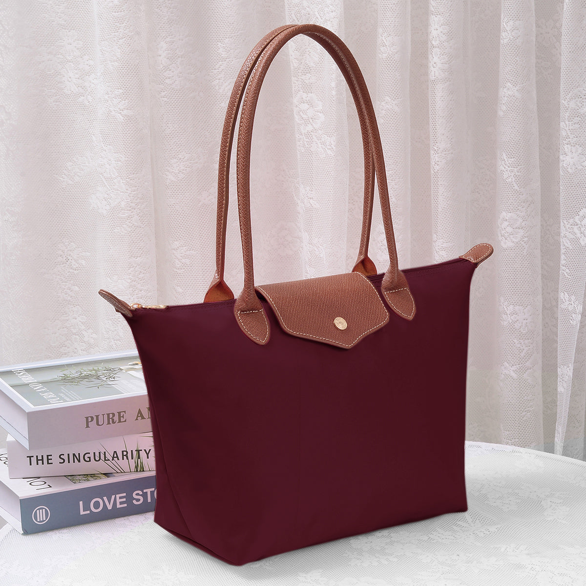 Burgundy luxe tote bag with tan leather handles and front patch pocket