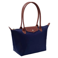 Navy blue handbag with brown handles and trim on a light background