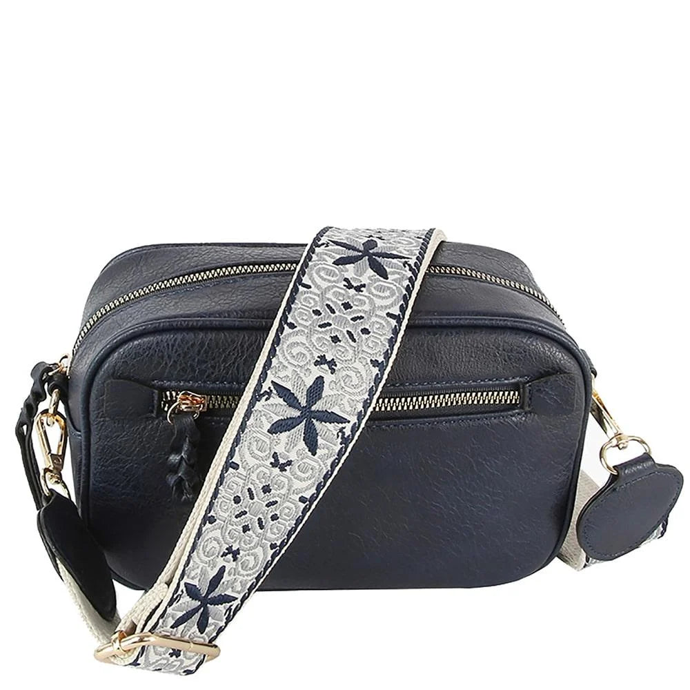 Black leather guitar strap crossbody bag featuring a decorative floral strap