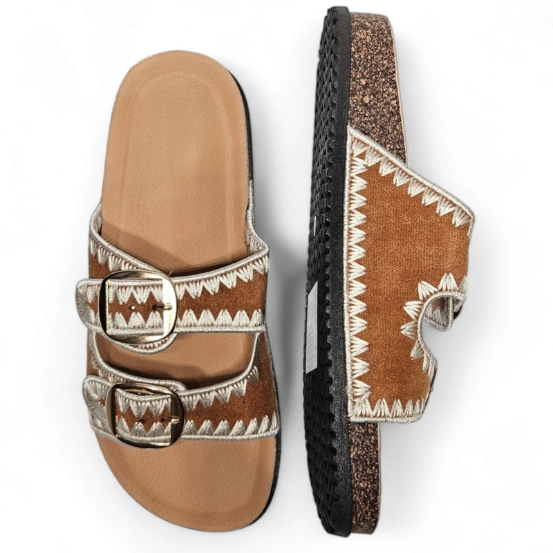 Pair of brown leather Boho Vacation Sandals with decorative white stitching and buckle straps