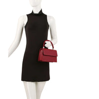 Sleeveless black turtleneck mini dress paired with a red handle satchel for a chic look