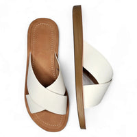 Pair of white criss cross sandal slides with tan soles for stylish summer comfort