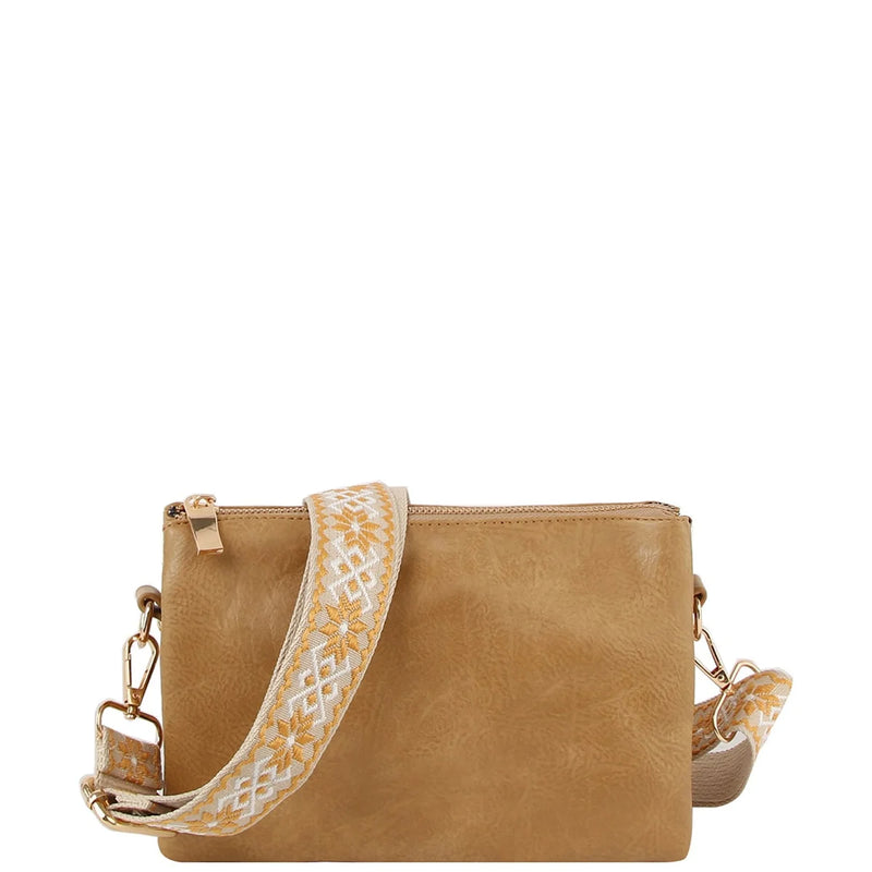 Tan leather crossbody bag clutch featuring a decorative woven guitar strap