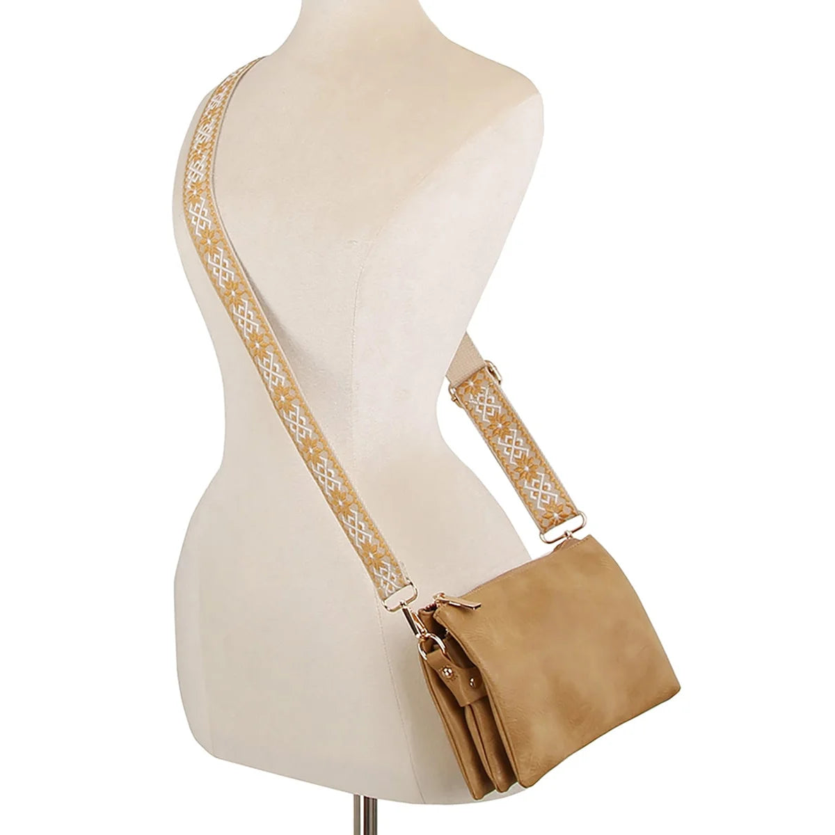 Tan leather crossbody bag clutch with decorative strap on mannequin torso display