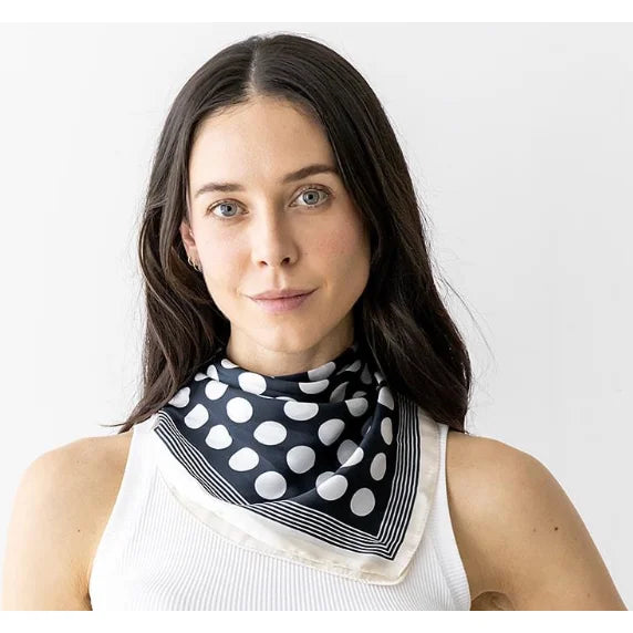 Polka dot navy and white silky neck scarf styled as a chic neckerchief