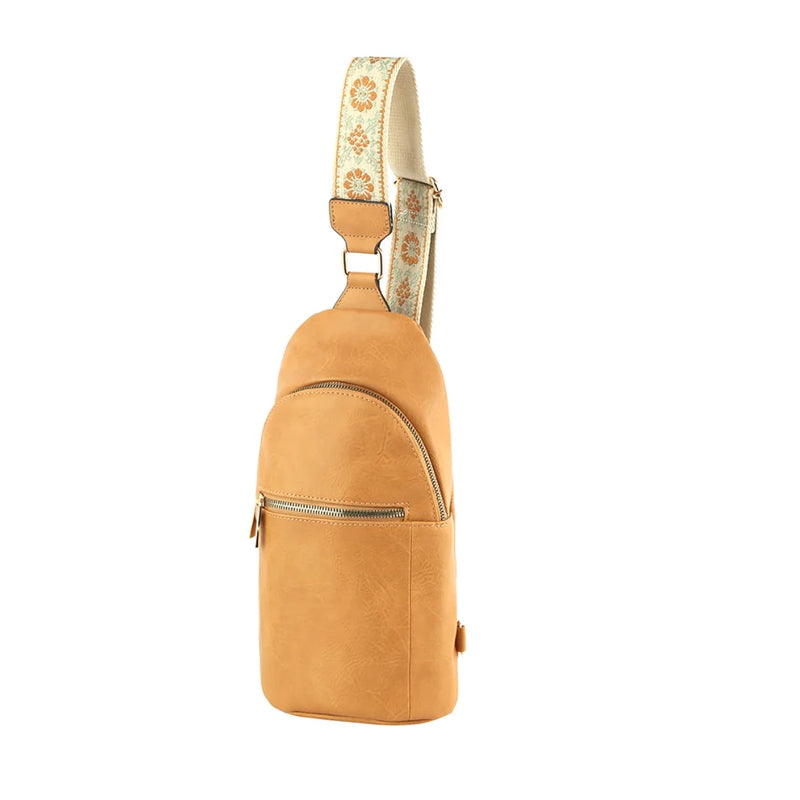 Tan leather zipper strap sling bag with decorative patterned strap for stylish outfits