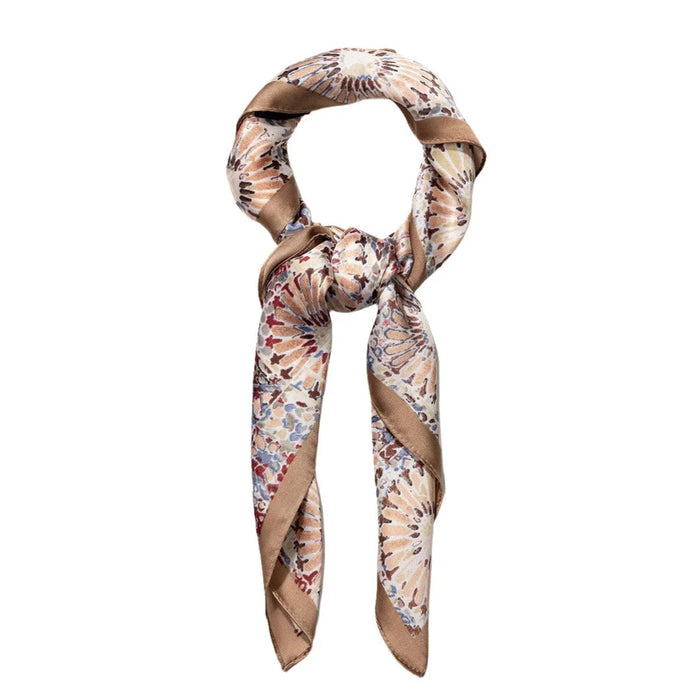 Floral patterned silk scarf in a loop featuring a vibrant firework print design