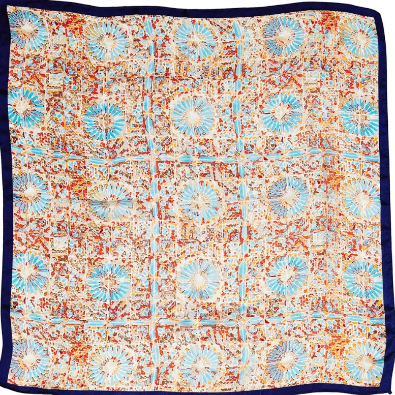 Patterned silk scarf featuring blue floral designs on a multicolored firework print background