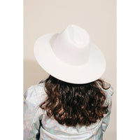 White flat brim fedora hat on dark curly hair, stylish and trendy for any occasion