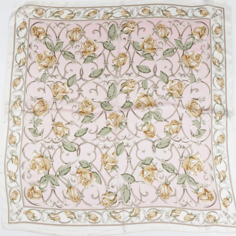 Floral pattern silk scarf featuring yellow flowers and green leaves on pale pink background