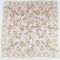 Floral pattern silk scarf featuring yellow flowers and green leaves on pale pink background