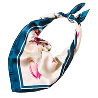 Silk scarf with floral pattern and blue border tied in a knot, flower pattern silky design