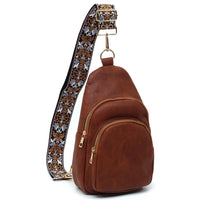 Brown leather guitar strap sling bag featuring a floral patterned strap for style