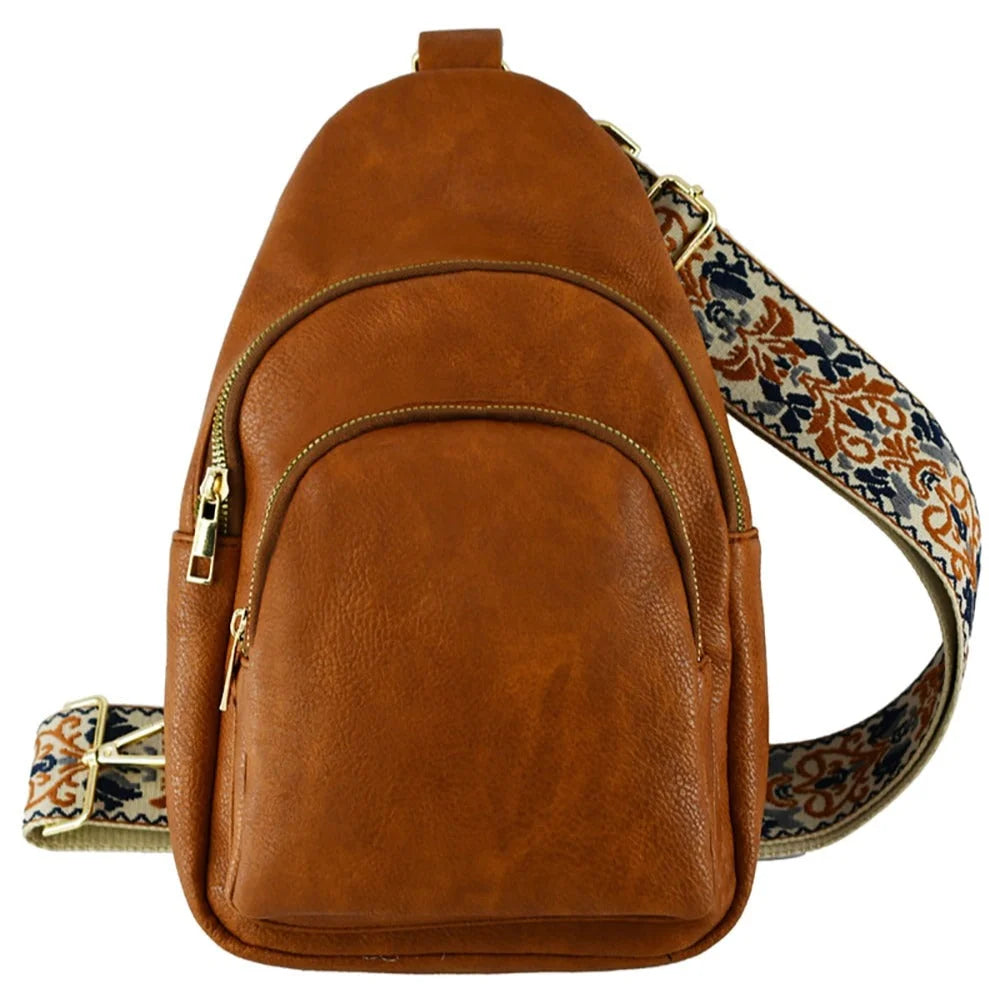 Brown leather strap sling bag featuring a decorative patterned guitar strap