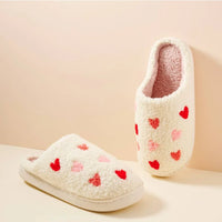 White fuzzy heart cozy slippers with red heart patterns for comfortable lounging