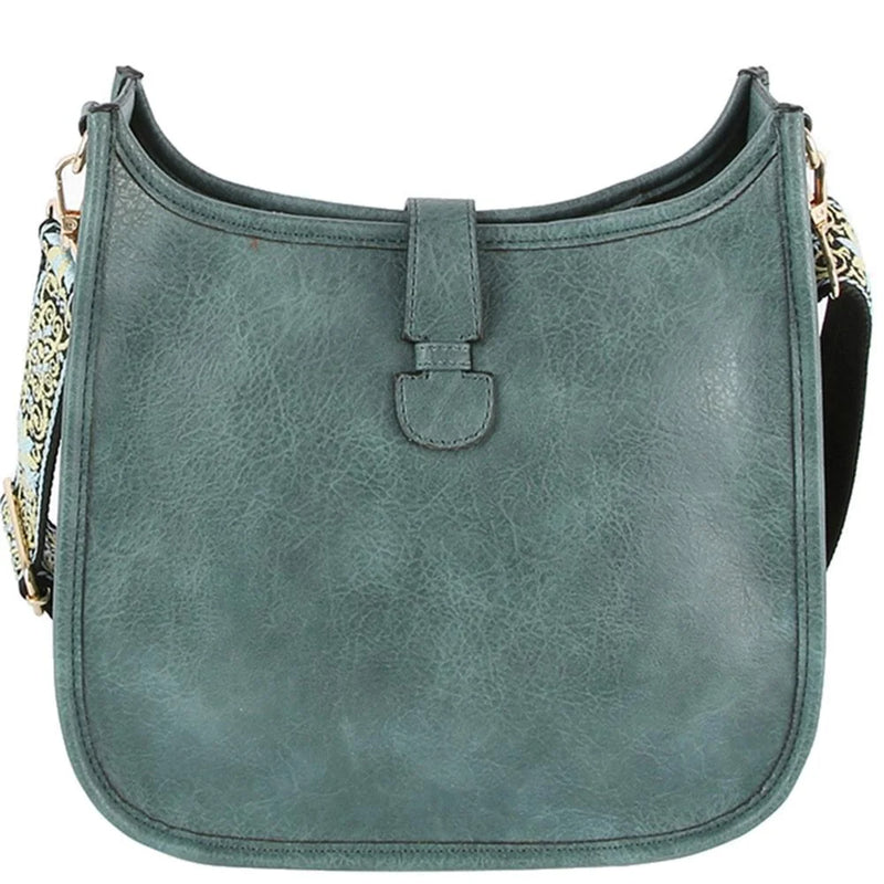 Teal leather hobo crossbody bag with curved shape and decorative guitar strap