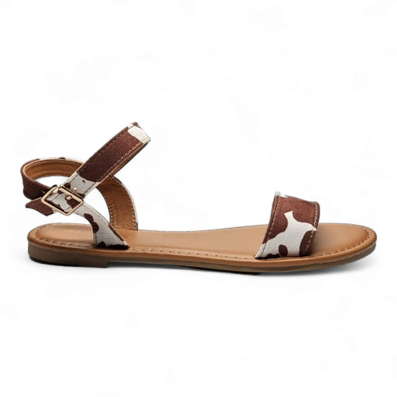 Flat cow print sandal featuring brown leather straps for stylish summer wear