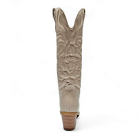 Tall beige cowboy boot with western-inspired embroidered design and stacked wooden heel