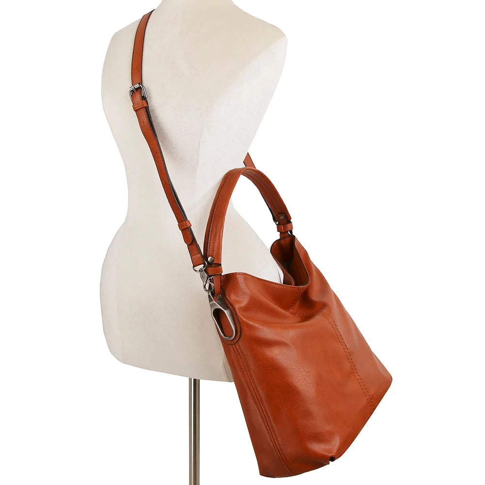 Brown leather modern hobo bag with adjustable strap displayed on mannequin torso