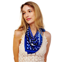 Blue polka dot scarf with white stripes elegantly worn around the neck in a stylish look