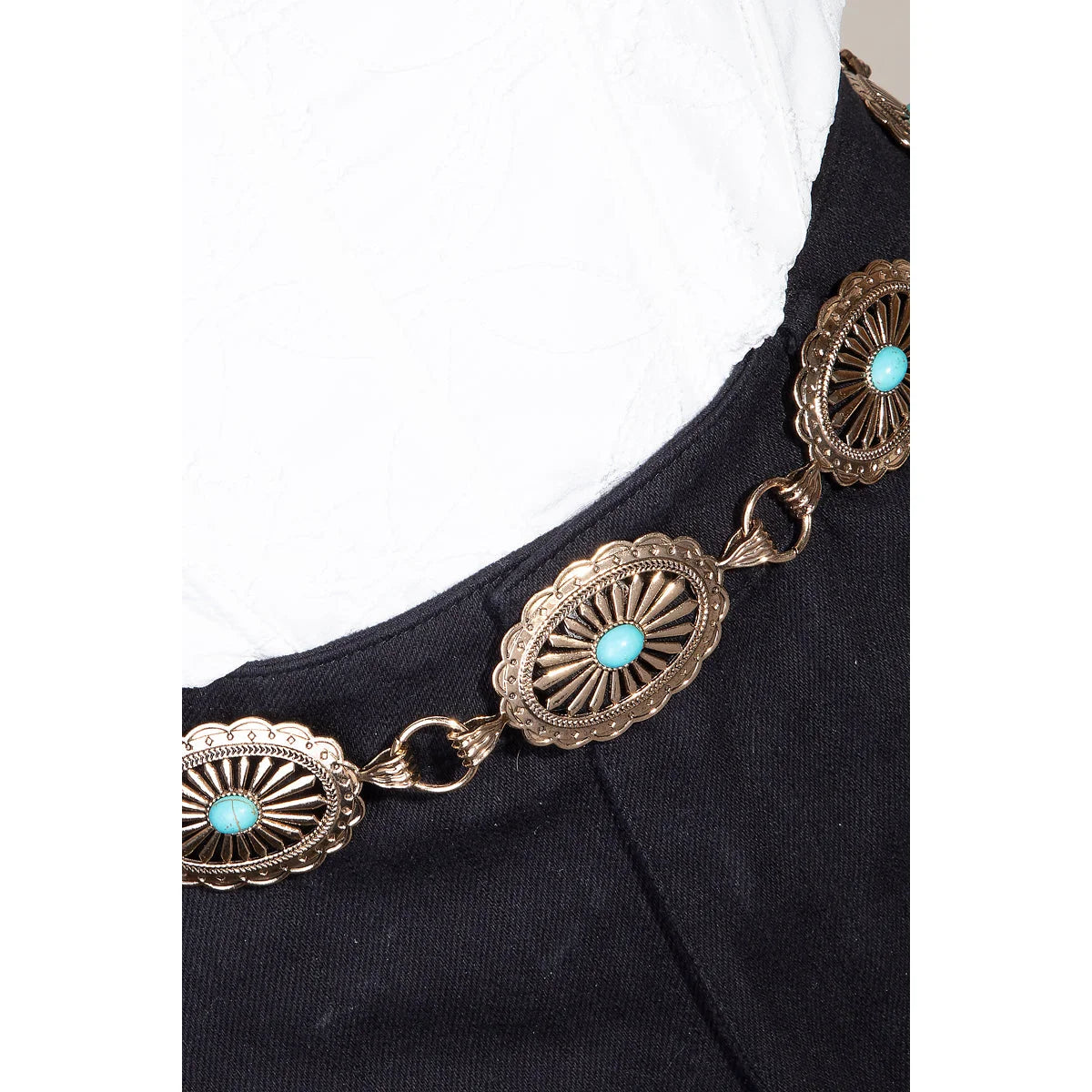 Ornate metallic oval chain belt draped over black fabric with silver and turquoise conchos