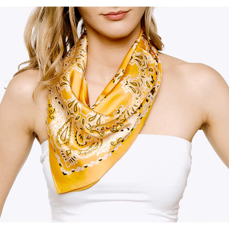 Yellow patterned paisley print silk scarf elegantly draped around a neck