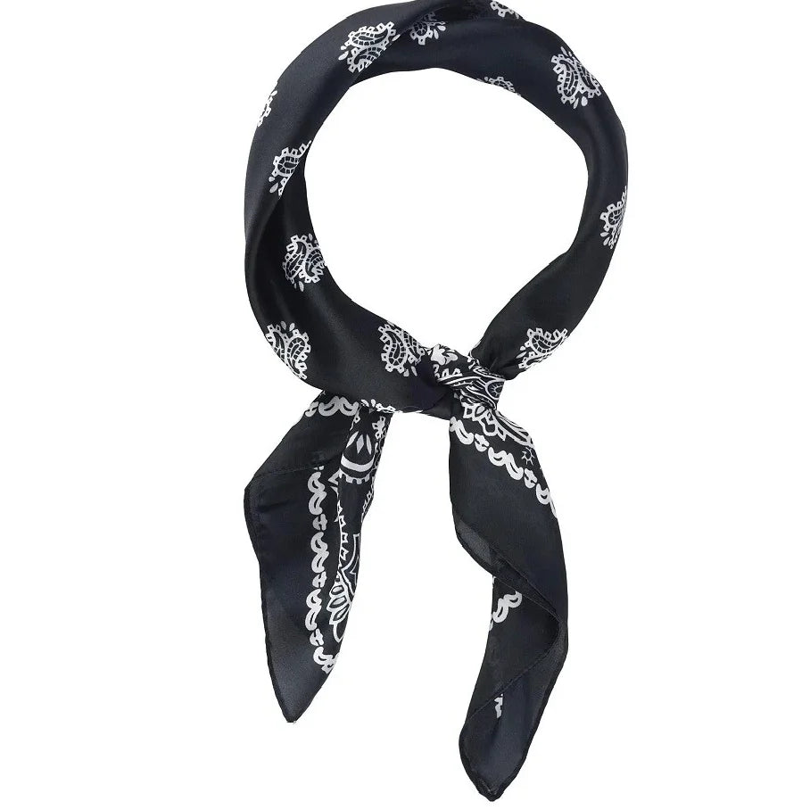 Black silk scarf with white paisley pattern elegantly tied in a loop