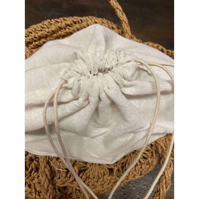 White fabric drawstring pouch for storing essentials with Patterned Straw Tote Bag