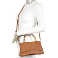 Tan leather handbag with curved wooden handles and a shoulder strap for stylish use