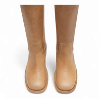 Tan leather mid-calf Riggs boots with rounded toes and flat soles, 15 inch shaft