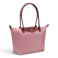 Light pink luxe tote bag with brown leather handles and front patch pocket