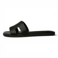Black slide sandals with H-band upper and flat slide sole, side view