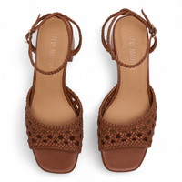 Brown woven sandals with ankle straps on a white background