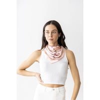 Woman in a white crop top with a pink patterned neck scarf for stylish outfits