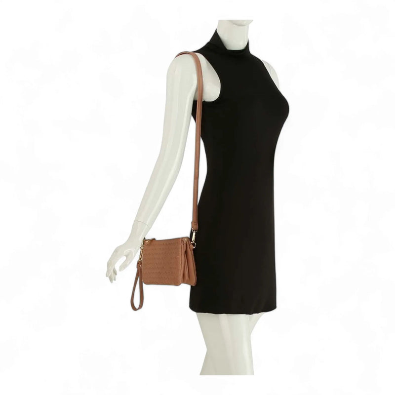 Sleeveless black turtleneck dress paired with a small woven crossbody bag