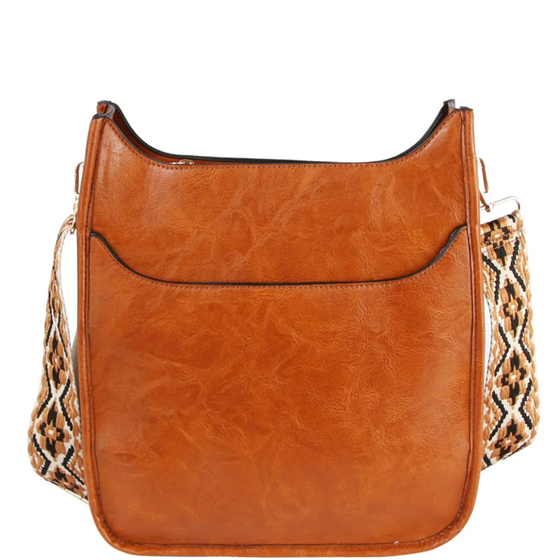 Tan leather crossbody bag featuring a patterned fabric guitar strap