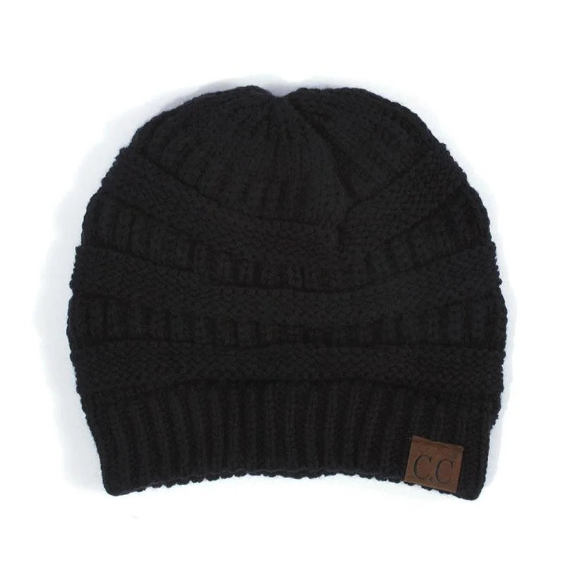 Black solid knit C.C Beanie hat featuring a small brown leather tag