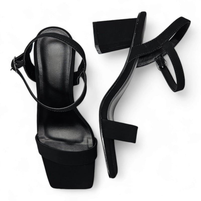 Black high-heeled platform sandals with ankle straps, featuring a stylish square toe design