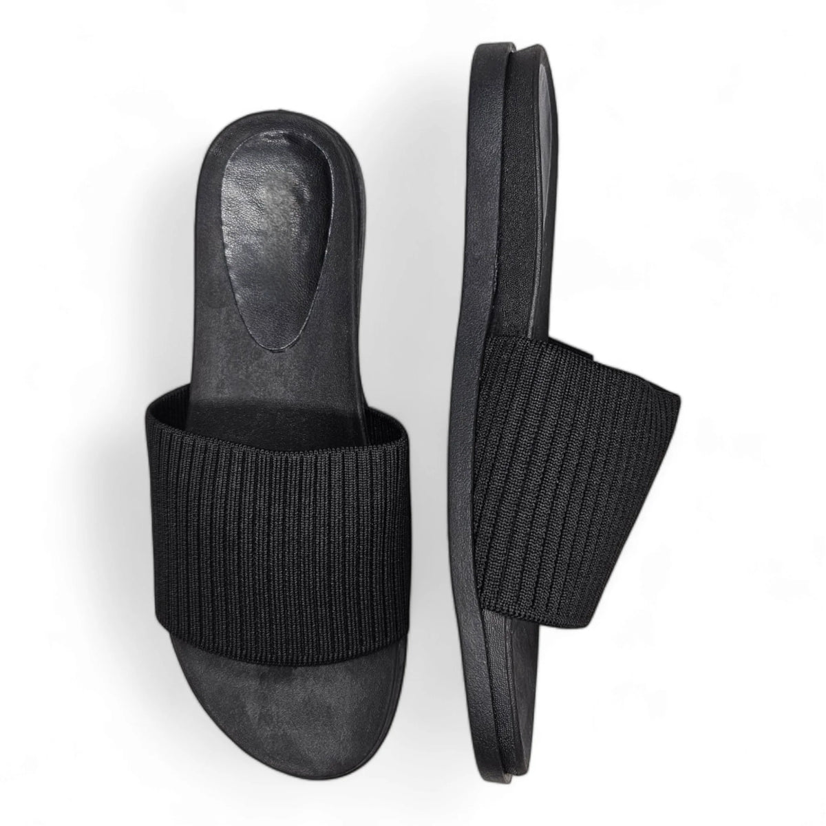 Black slide sandal featuring a stretch woven upper and ribbed fabric strap