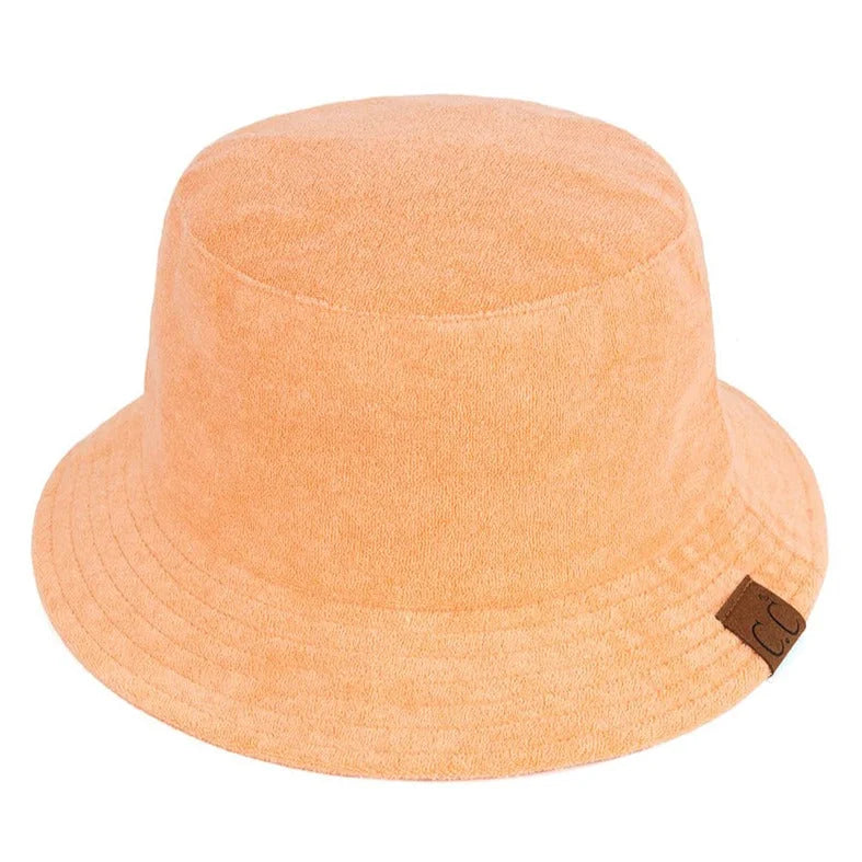 Peach terry cloth bucket hat featuring a small brown label for stylish summer wear
