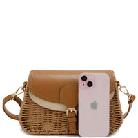 Woven crossbody bag with leather accents featuring a two tone straw design