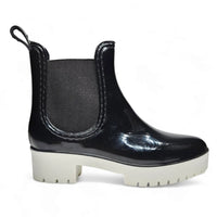 Black glossy Chelsea rain bootie with a stylish white chunky sole for wet weather