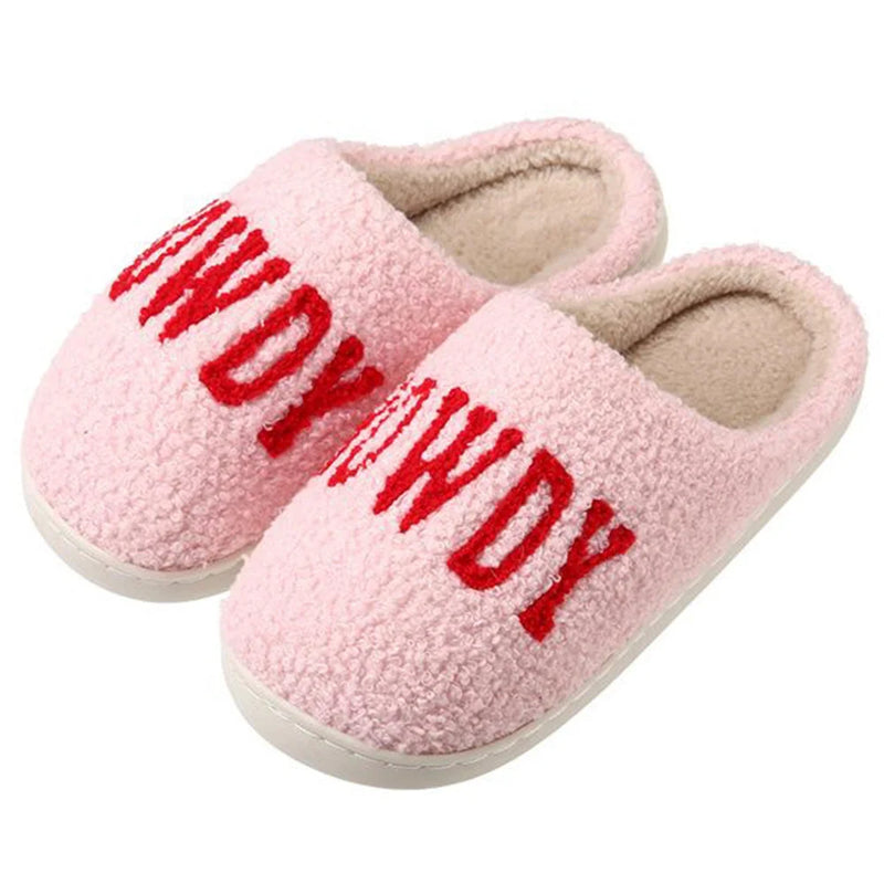 Pink fuzzy Western Howdy Slippers with bold red text printed on them