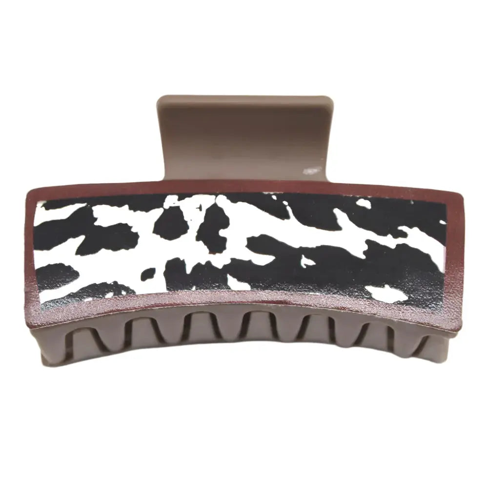 Cow print hair claw jaw clip featuring black and white pattern with brown edges