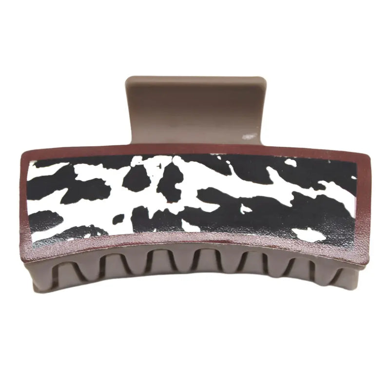 Cow print hair claw jaw clip featuring black and white pattern with brown edges