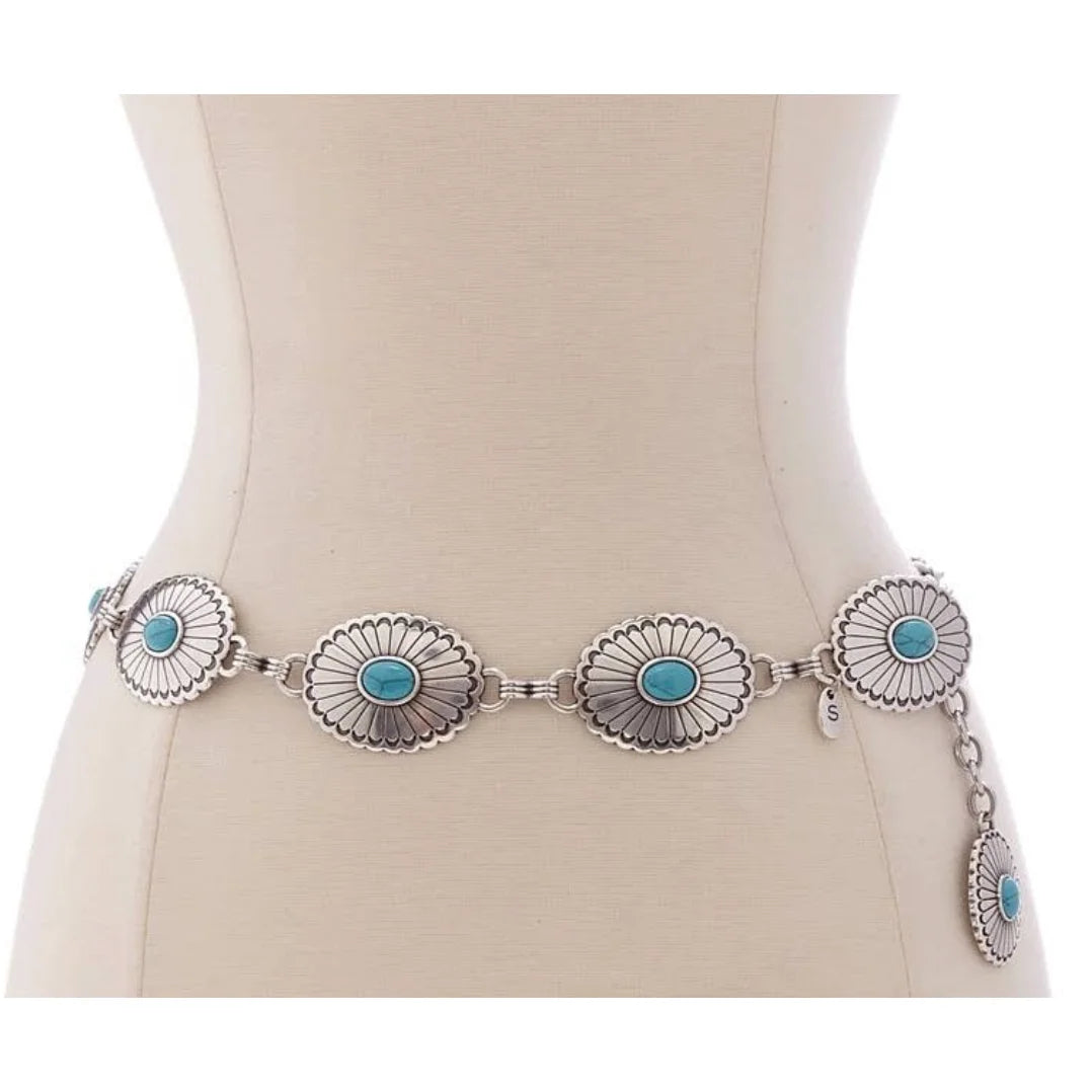 Silver concho belt with turquoise stones on a mannequin, showcasing western style metal